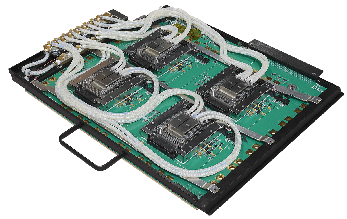 A green server motherboard featuring four processors equipped with a liquid cooling system consisting of white braided tubing and metal heat blocks.