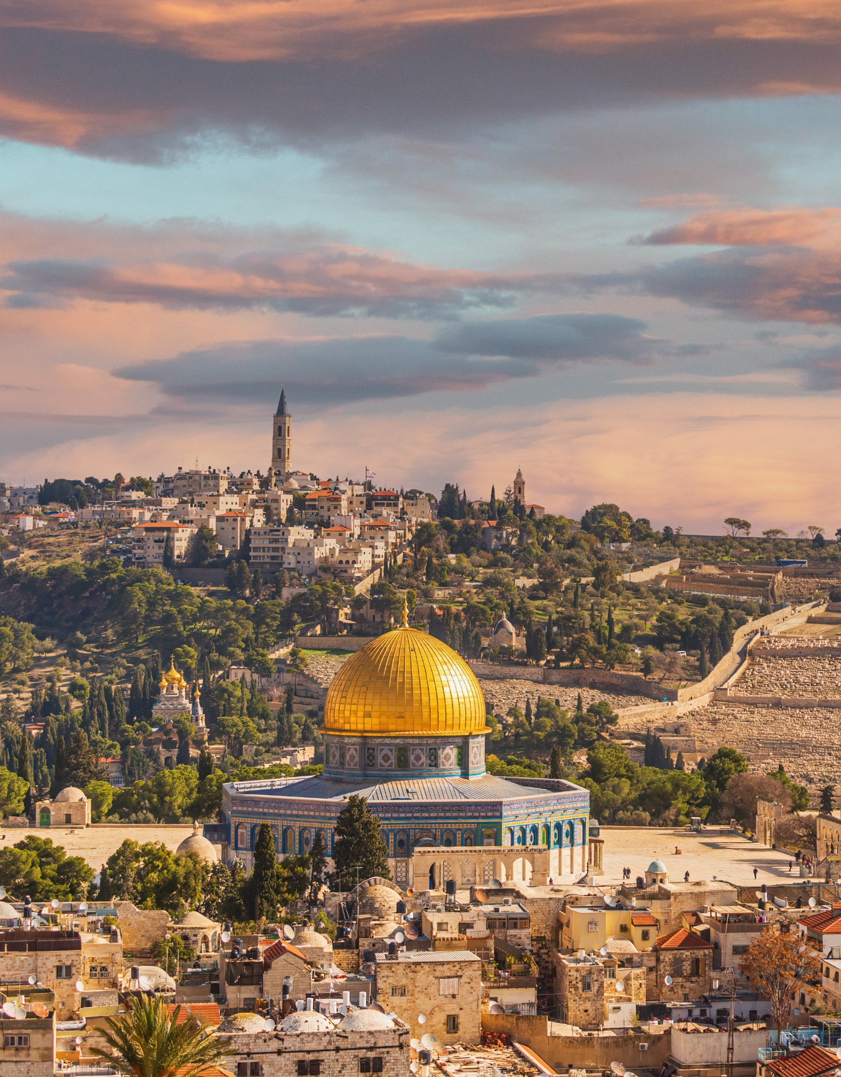 The golden Dome of the Rock stands prominently in the foreground of Jerusalem’s Old City at sunset.