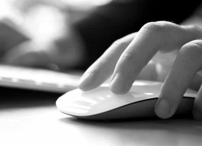 A hand resting on a computer mouse.
